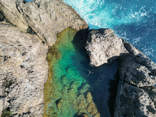 Aerial view of a beautiful natural pool of crystal clear water with a person swimming. Tenerife, Canary Islands