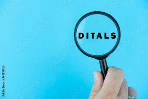 Focused on DITALS exam. Word DITALS (Didattica dell'Italiano come Lingua Straniera) under magnifying glass. Italian Language Proficiency Test. Test Preparation. E-learning. photo