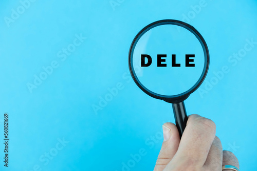 Focused on DELE exam. Word DELE (Diploma de Español como Lengua Extranjera) under magnifying glass. Spanish Language Proficiency Test. Test Preparation. E-learning. photo
