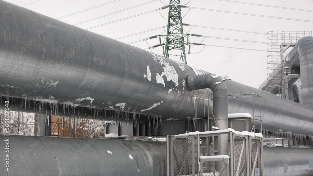 pipeline and power line in the city in winter against the gray sky pipeline and power line in the city in winter against the gray sky