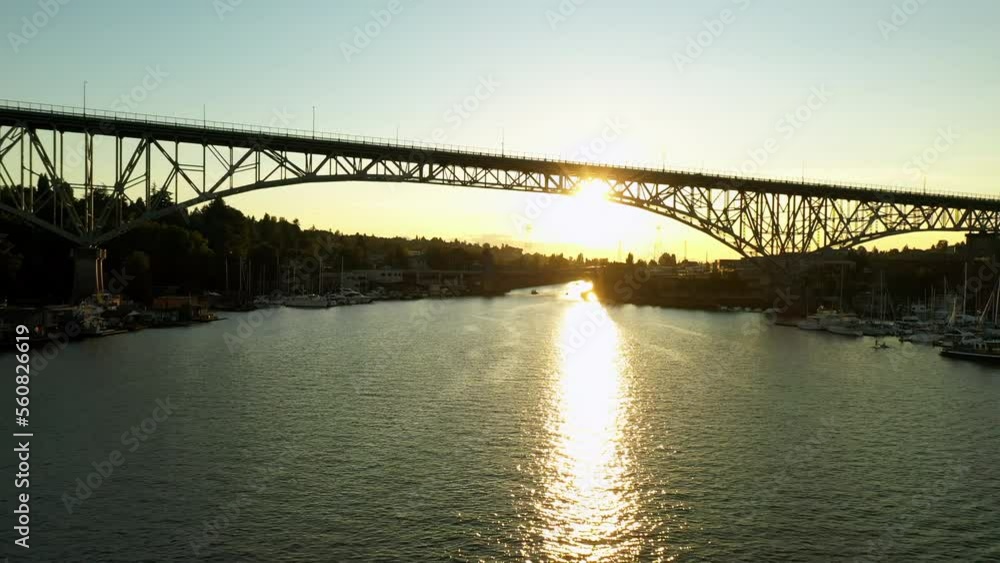 Aerial Forward Shot Of Vehicles Moving On Bridge Over Sea With Boats Moored At Harbor During Sunset - Seattle, Washington Aerial Forward Shot Of Vehicles Moving On Bridge Over Sea With Boats Moored At Harbor During Sunset - Seattle, Washington