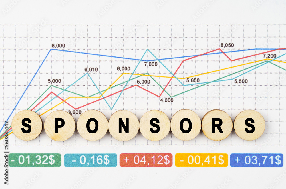 Fototapeta premium On the financial charts are wooden mugs with the inscription - Sponsors