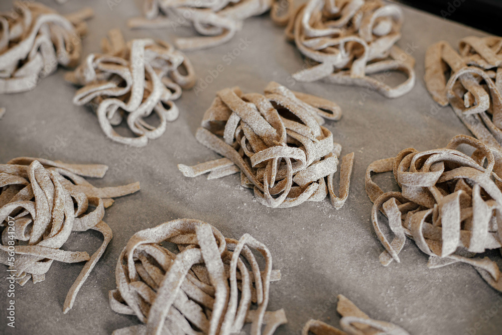 Homemade pasta. Dry fettuccine noodles in nests on baking tray close up. Making whole-grain pasta Homemade pasta. Dry fettuccine noodles in nests on baking tray close up. Making whole-grain pasta