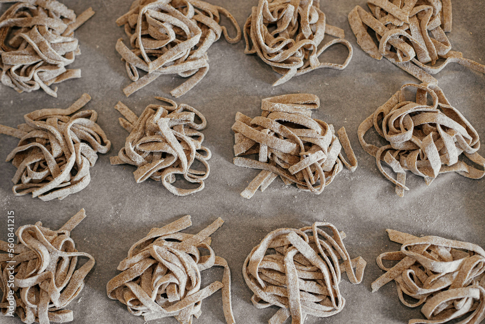 Homemade pasta. Dry fettuccine noodles in nests on baking tray close up. Making whole-grain pasta Homemade pasta. Dry fettuccine noodles in nests on baking tray close up. Making whole-grain pasta