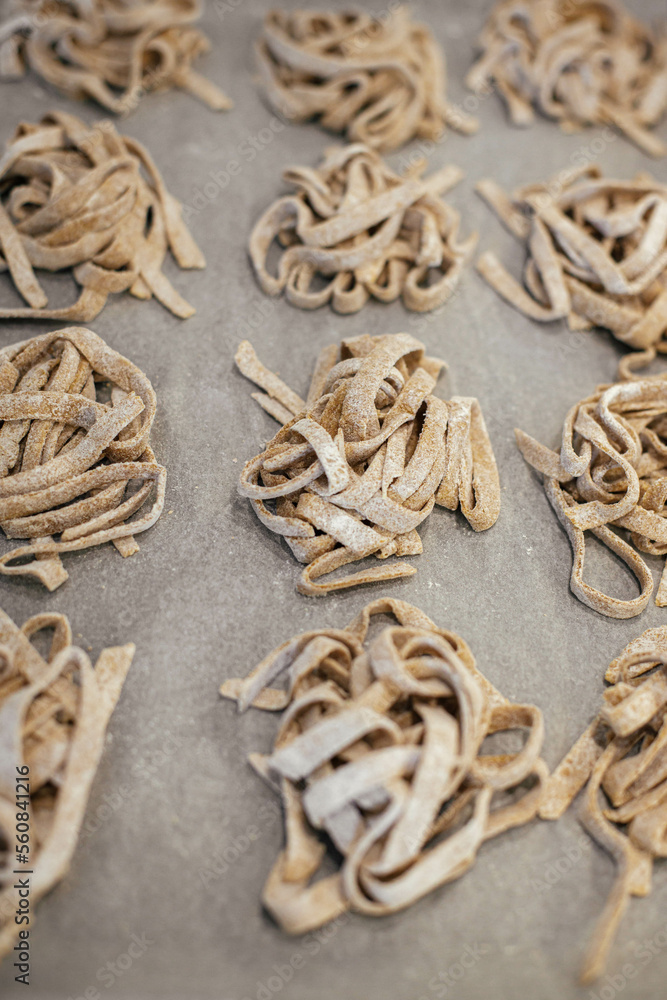 Homemade pasta. Dry fettuccine noodles in nests on baking tray close up. Making whole-grain pasta Homemade pasta. Dry fettuccine noodles in nests on baking tray close up. Making whole-grain pasta