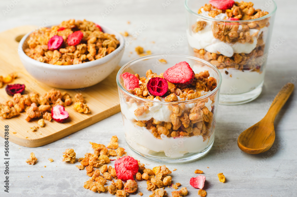 Granola and Yogurt Parfaits, Healthy Breakfast or Snack, Muesli with Dried Berries on Bright Concrete Background Granola and Yogurt Parfaits, Healthy Breakfast or Snack, Muesli with Dried Berries on Bright Concrete Background