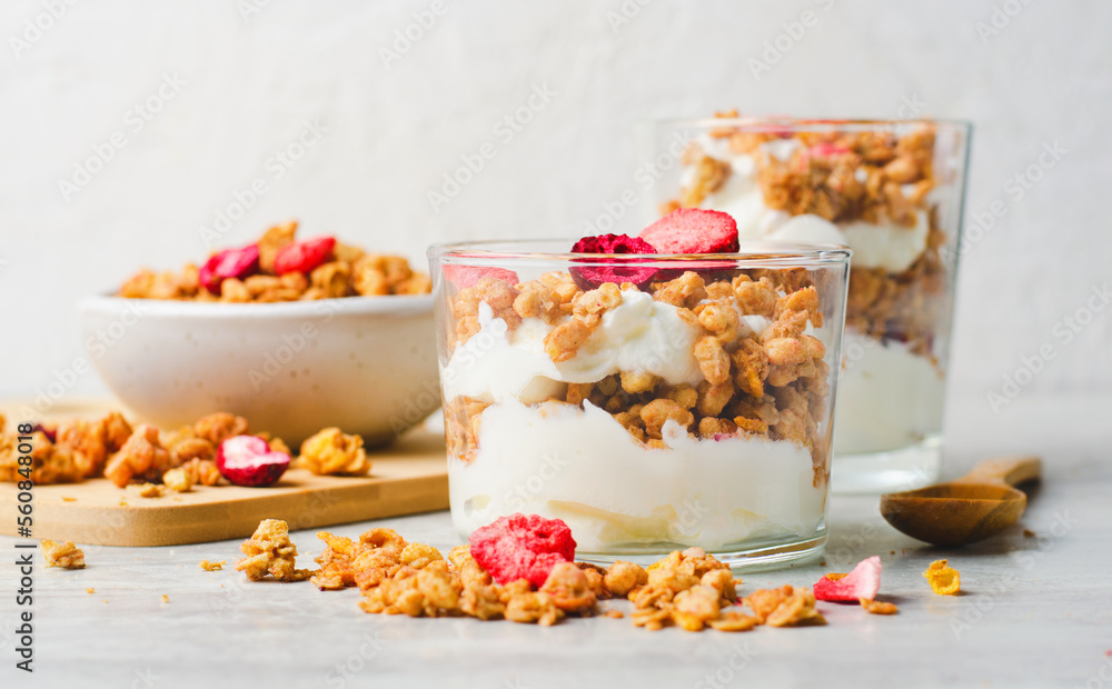 Granola and Yogurt Parfaits, Healthy Breakfast or Snack, Muesli with Dried Berries on Bright Concrete Background Granola and Yogurt Parfaits, Healthy Breakfast or Snack, Muesli with Dried Berries on Bright Concrete Background