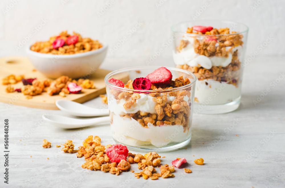 Granola and Yogurt Parfaits, Healthy Breakfast or Snack, Muesli with Dried Berries on Bright Concrete Background Granola and Yogurt Parfaits, Healthy Breakfast or Snack, Muesli with Dried Berries on Bright Concrete Background