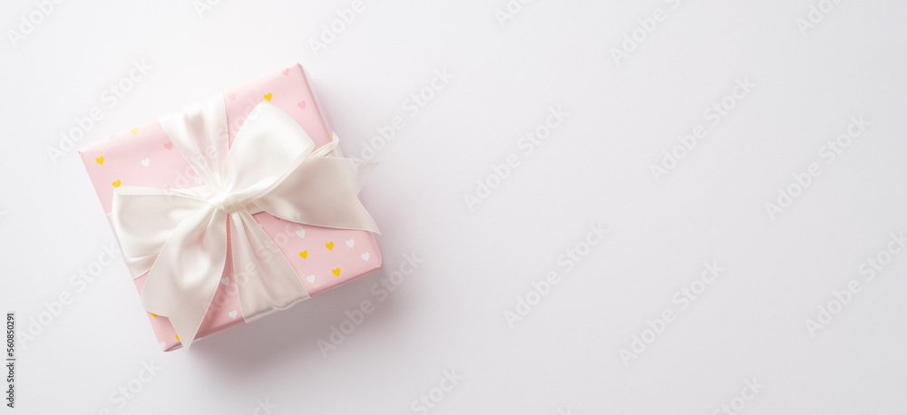 Saint Valentine's Day concept. Top view photo of pastel pink present box with silk ribbon bow on isolated white background with copyspace Saint Valentine's Day concept. Top view photo of pastel pink present box with silk ribbon bow on isolated white background with copyspace