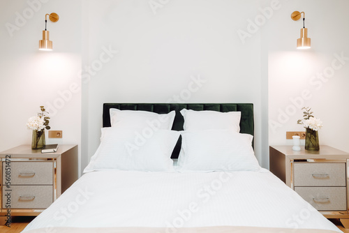 Close up of bed in master bedroom. Details of high end home design with exquisite furniture, golden light fixtures. Master bedroom design