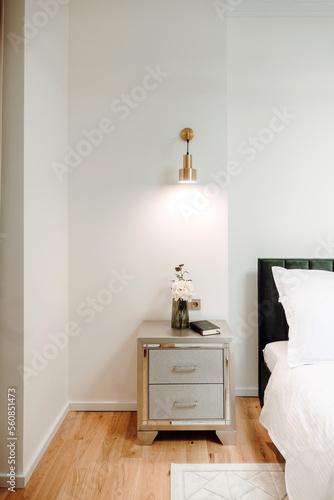 Close up of bed in master bedroom. Details of high end home design with exquisite furniture, golden light fixtures. Master bedroom design