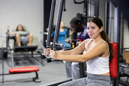 Caucasian woman doing exercises on chest fly machine in gym