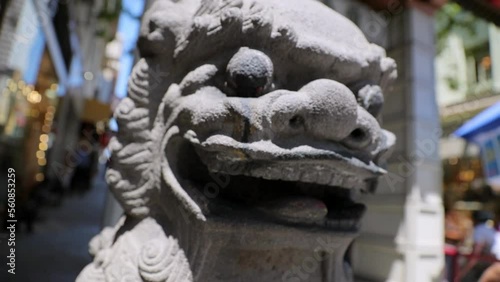 Close-Up Slow Motion Shot Of Stone Sculpture By People Walking At Chinatown During Sunny Day - San Francisco, California photo