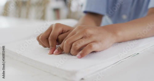 Wallpaper Mural Close up of african american boy sitting at table and reading braille Torontodigital.ca