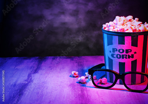 Cinema movies concept background, with a pop corn bucket, 3D glasses and copy space for text. Movie night template, table top photography commercial shot, with a retro purple, aesthetic.