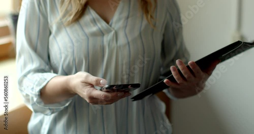 An unrecognizable female social worker uses phone to perform her professional duties. Woman call the client to confirm the appointment. Online coordination volunteering.