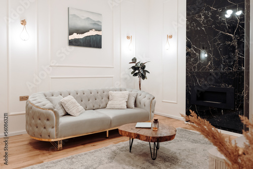 Stylish living room details and modern design with sofa, details of couch fabric and pillows. Boho design, comfortable sofa with textures and modern furniture next to fireplace