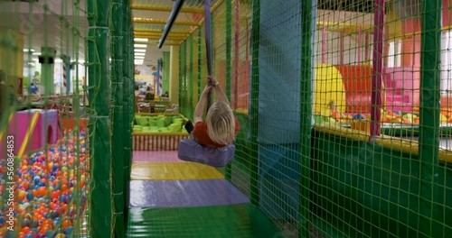 Teenage boy merrily rides bungee. Fun time for kids indoors. Childrens entertainment complex. Happy childhood