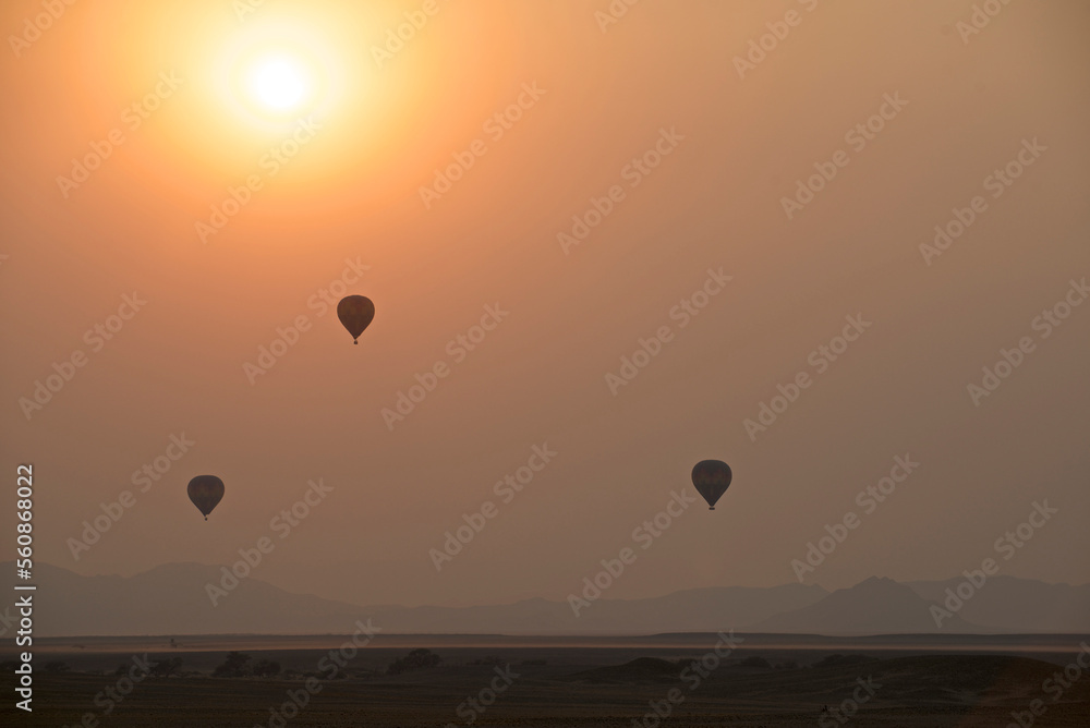 Hot air balloons rise at sunrise in Sossusvlei, Namibia Hot air balloons rise at sunrise in Sossusvlei, Namibia
