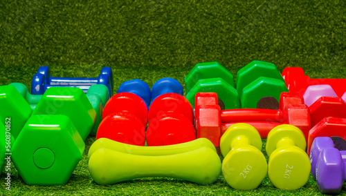 multi-colored dumbbells on a background of green grass