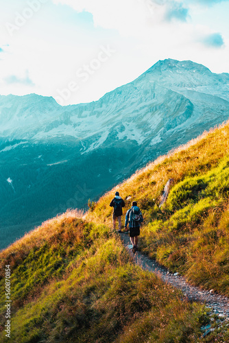 Hikers on the way to the Alps Mountains during the sunset.