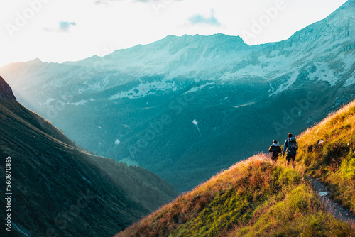 Hikers on the way to the Alps Mountains during the sunset.