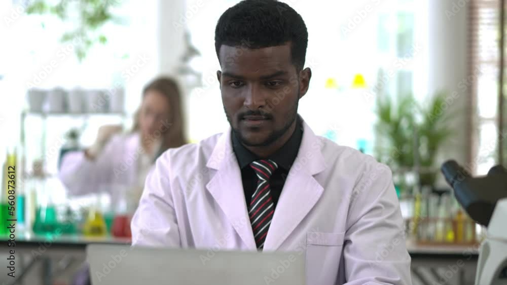 Young Scientist man typing on laptop computer while working lab Young Scientist man typing on laptop computer while working lab