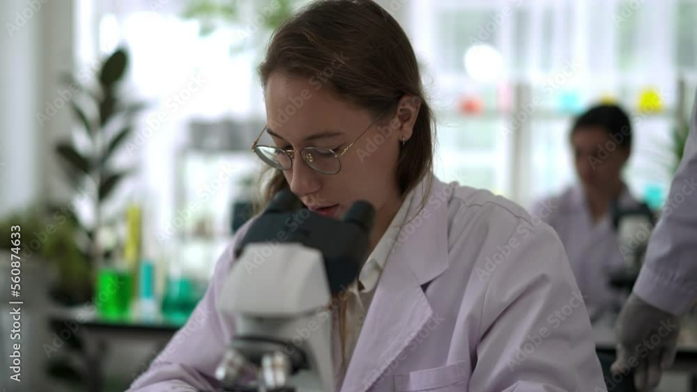 Young woman scientist working with microscope in Laboratory Young woman scientist working with microscope in Laboratory