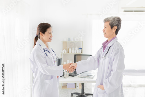 two doctor shaking hand together in hospital  hand in hand  be in unity and teamwork  they feeling happy in work time