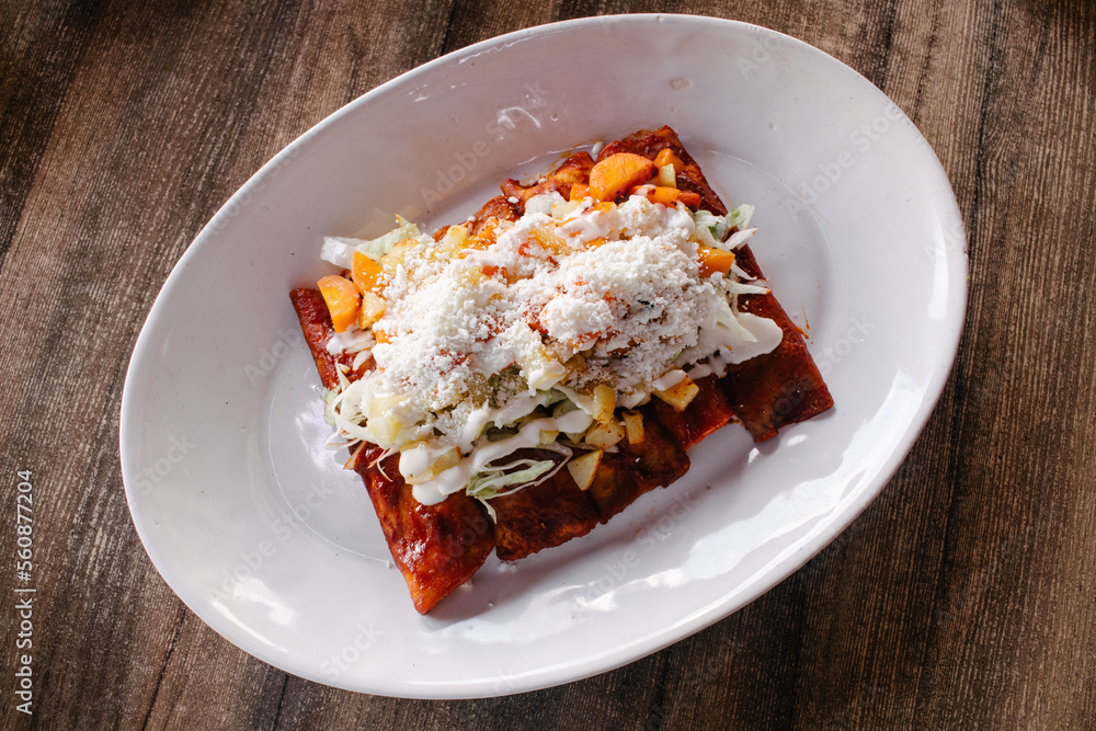 Enchiladas con lechuga, queso, crema, papa y zanahoria Stock Photo
