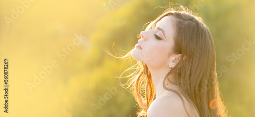 Spring woman on sunlight romantic portrait, sensual sunny face. Banner for website header. Portrait of a young woman, close up face of beautiful woman outdoor side profile portrait. photo