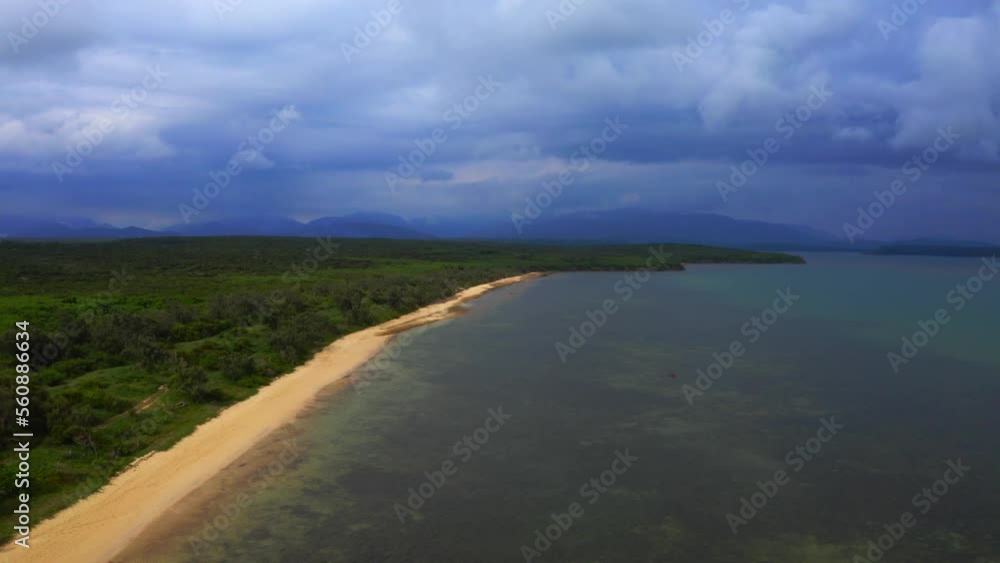 From above, the drone captures a stunning view of the tropical beach as it emerges from the clouds, its beauty and tranquility undimmed by the grey skies overhead. From above, the drone captures a stunning view of the tropical beach as it emerges from the clouds, its beauty and tranquility undimmed by the grey skies overhead.