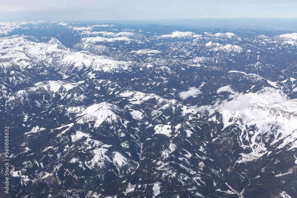 Snow capped mountains aerial view . Flying over the snowy peaks