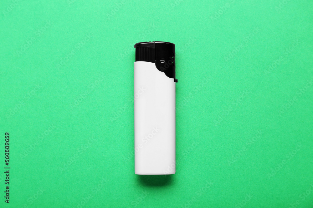 Stylish small pocket lighter on green background, top view Stylish small pocket lighter on green background, top view