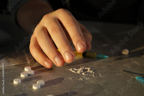 Addicted man with drugs at grey textured table, closeup
