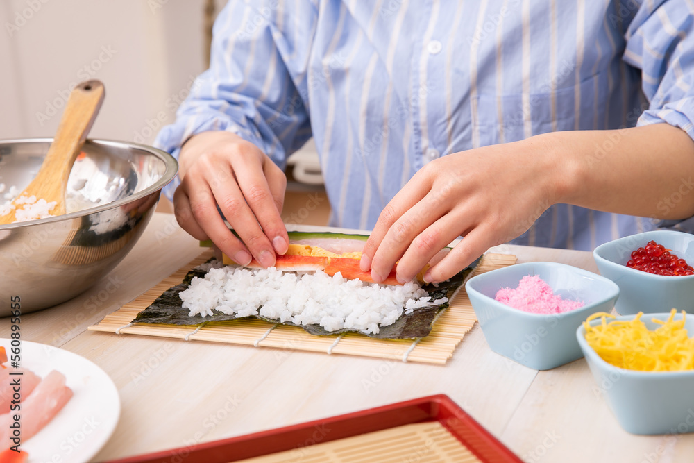 手巻き寿司を巻く女性の手元　cooking