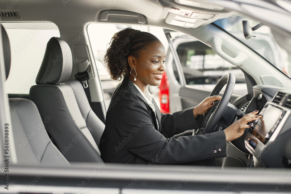 Portrait of black female driver in a car wearing black costume