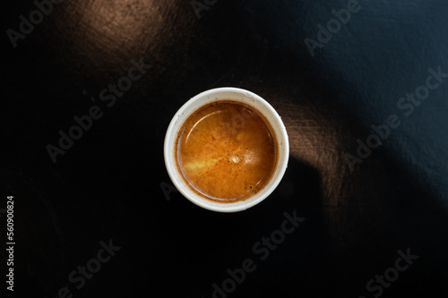 black coffee on a paper cup served on white table at cafe​