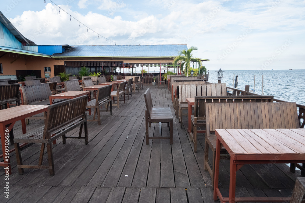 empty wooden table and chairs in seaside cafe empty wooden table and chairs in seaside cafe