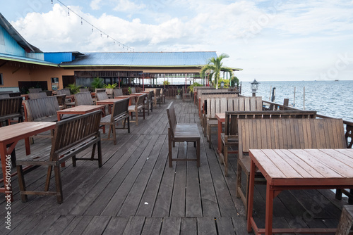 empty wooden table and chairs in seaside cafe