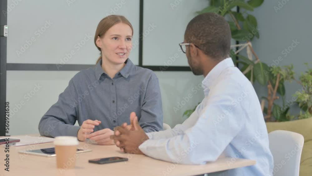 Young Woman Talking to African Man in Office Young Woman Talking to African Man in Office