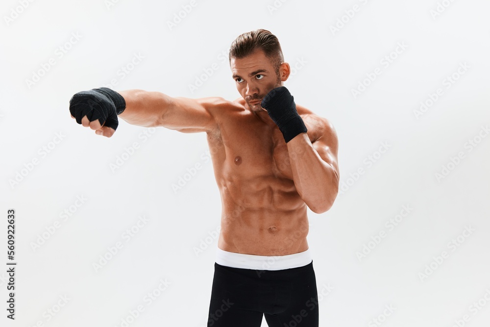 Man athletic bodybuilder poses in boxing gloves with nude torso abs in full-length background, boxing and martial arts. Advertising, sports, active lifestyle, competition, challenge concept. Man athletic bodybuilder poses in boxing gloves with nude torso abs in full-length background, boxing and martial arts. Advertising, sports, active lifestyle, competition, challenge concept.