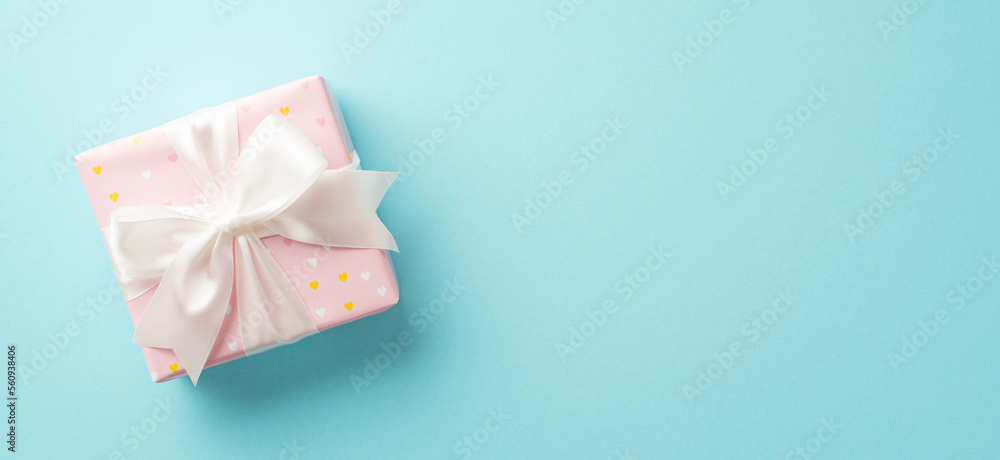 Valentine's Day concept. Top view photo of pastel pink giftbox with white ribbon bow on isolated light blue background with copyspace Valentine's Day concept. Top view photo of pastel pink giftbox with white ribbon bow on isolated light blue background with copyspace