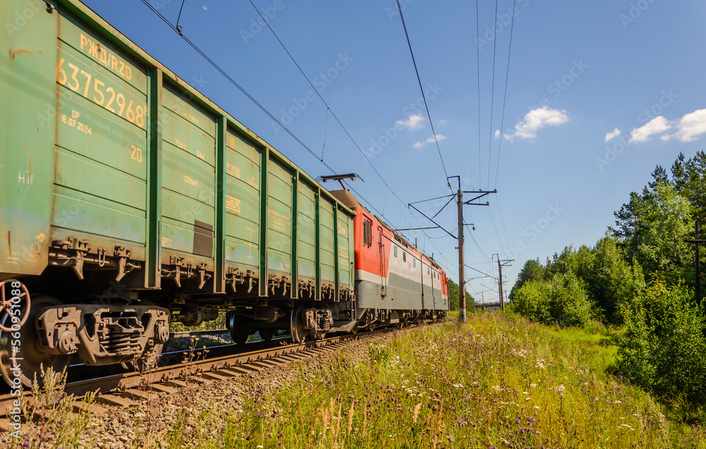An electric locomotive with cars rides on rails.Railway train. An electric locomotive with cars rides on rails.Railway train.