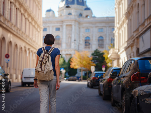 summer female solo trip to Europe, happy young woman walking on european street of Vienna, Austria