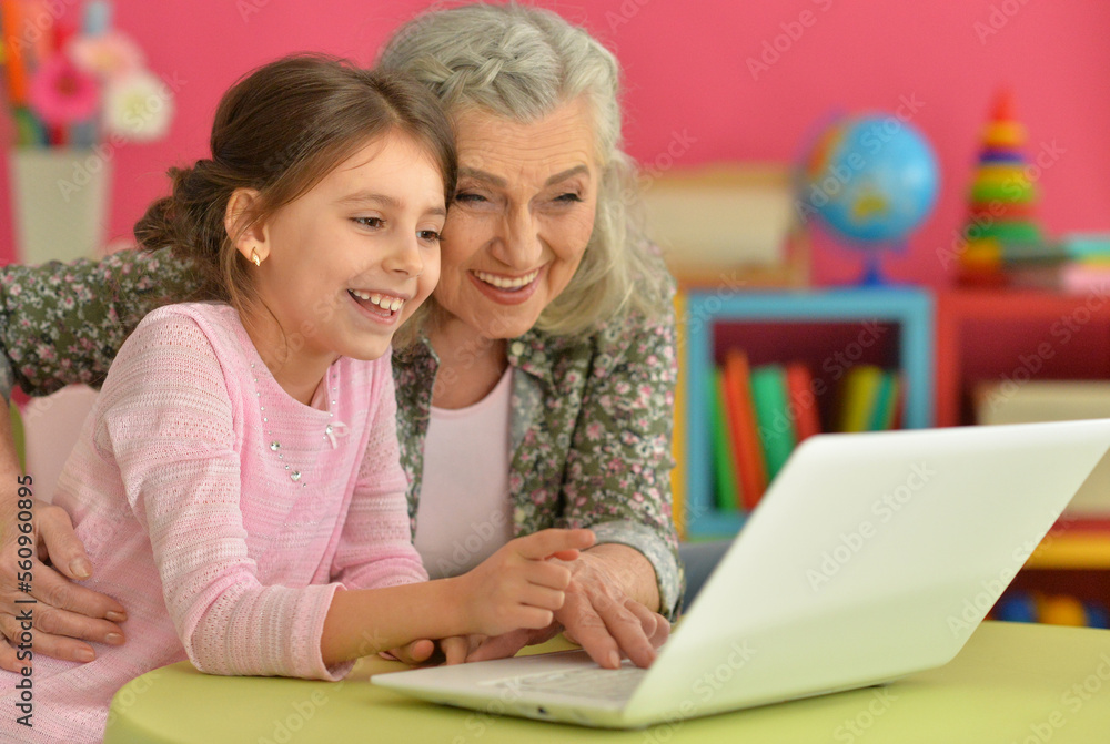 portrait of happy grandmother and daughter using laptop portrait of happy grandmother and daughter using laptop