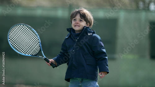 One little boy holding tennis racket playing outside © Marco