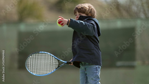 One little boy holding tennis racket playing outside © Marco