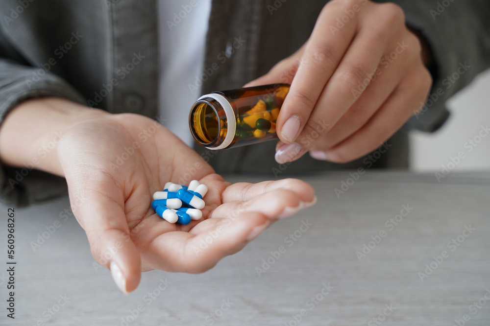 Woman pour pills into palm to take dietary supplements, vitamins or medicines. Health care, wellness Woman pour pills into palm to take dietary supplements, vitamins or medicines. Health care, wellness