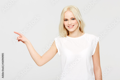 Woman, hand point and portrait of a model with marketing mock up with white background. Beauty, happy and hands sign of a person from Switzerland with happiness pointing at advertising concept